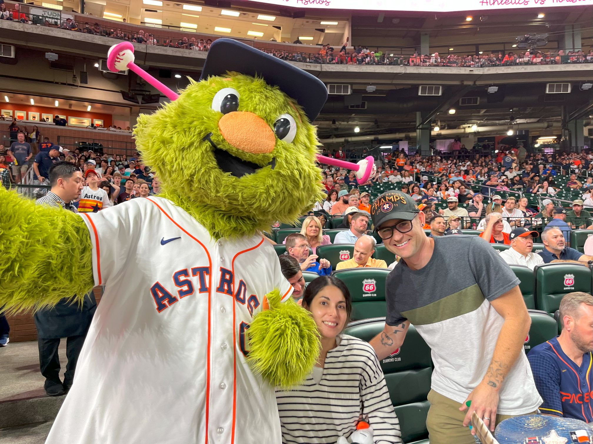 man and woman posing with Astros Mascot, Orbitz