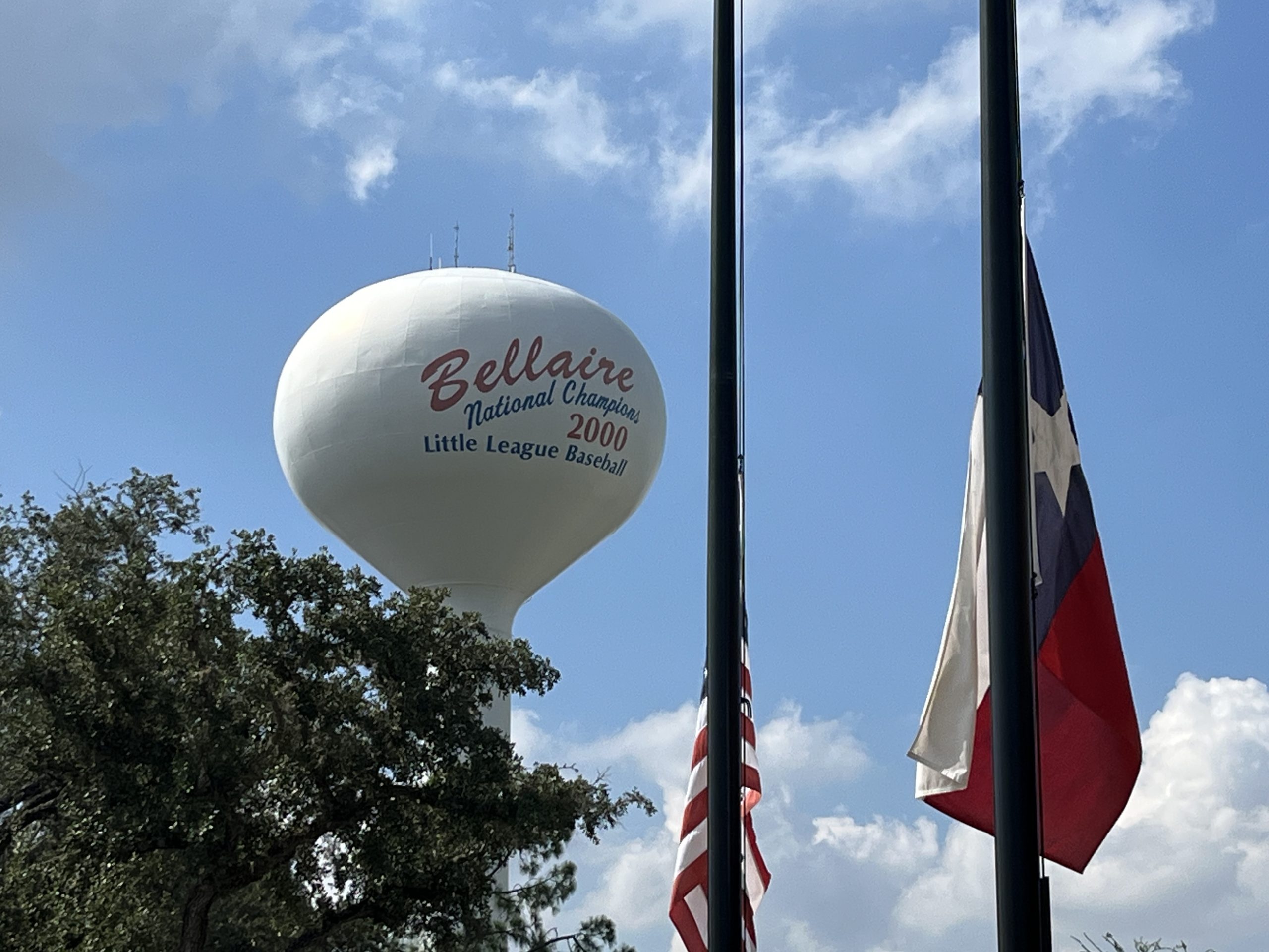 Water Tower with "Bellaire" written on it and Flags in foreground